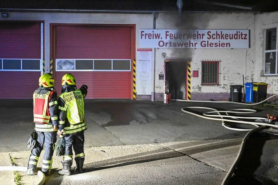 Feuerwehrleute vor der verrauchten Feuerwache der Ortswehr Glesien während des Löscheinsatzes.
